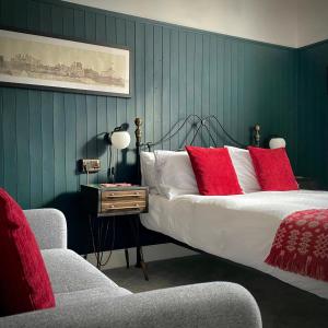 TrefriwCrafnant House - Bed & Breakfast的一间卧室配有一张带红色枕头的床和一把椅子