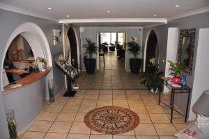 勒拉旺杜海滩酒店的走廊上设有盆栽和瓷砖地板