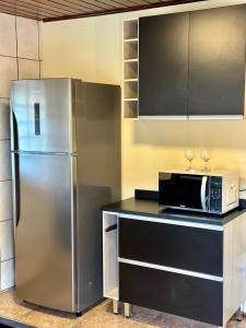 蒙特韦尔迪Pousada serrano的厨房配有不锈钢冰箱和微波炉。