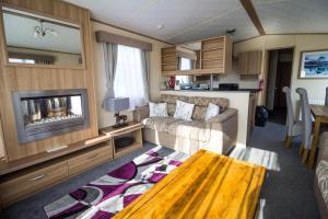劳斯8 Berth Caravan With Wifi At Sunnydale Park In Skegness Ref 35220kc的一个带沙发和电视的大篷车客厅