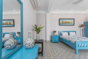美奈格雷斯精品度假村酒店的一间卧室配有两张蓝色的床和镜子