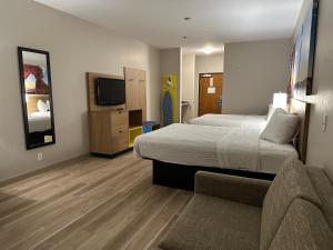 俄克拉何马城俄克拉荷马城戴斯酒店及套房 的一间卧室配有一张床、一张沙发和一台电视。
