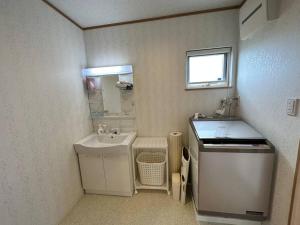KanayamaSHIRAHAMA condominium D-157的一间白色的小浴室,配有水槽和盥洗盆