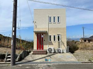 KanayamaSHIRAHAMA condominium D-157的一间设有红色门和两个扬声器的小房子