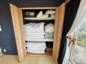 KanayamaSHIRAHAMA condominium D-157的客房内的衣柜配有毛巾和枕头