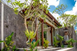 坎古Sanata Luxury Villa的一座有混凝土墙和树木的房屋