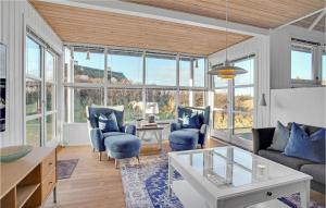 索尔图姆Cozy Home In Saltum With Indoor Swimming Pool的客厅设有蓝色家具和大窗户