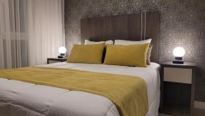 圣路易斯Be Haus Temporary Apartments的一间卧室配有一张带黄色枕头的大床