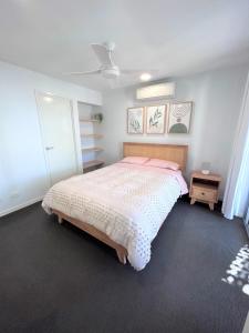 布里斯班Unit 3 - Manly Boutique Apartments的一间卧室配有一张带粉红色棉被的床