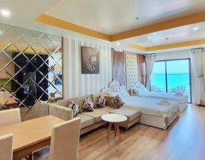 归仁TMS Quy Nhơn View Biển的一间卧室配有一张床、一张沙发和一张桌子