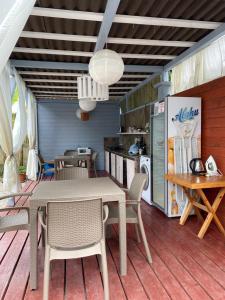加格拉Эко домики у моря в Гаграх的露台配有桌椅和冰箱。