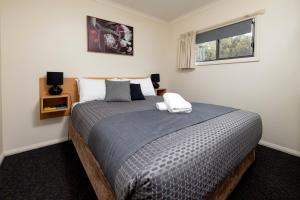 剑桥BIG4 Hobart Airport Tourist Park的一间卧室设有一张大床和窗户