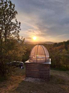 索科矿泉村Rtanj,Vrmdza,,Hotel sa hiljadu zvezdica"的地面上的小天文台,有日落的背景