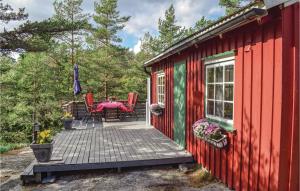 Seierstad拉尔维克韦斯特马克度假屋的红色和绿色的小屋,甲板上配有桌椅