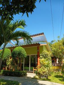 班柯木LUCKY Bungalows Koh Mook的一座黄色房子,前面有一棵棕榈树