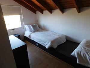 埃尔卡拉法特MI CASA TU CASA的一间卧室设有两张床和窗户。