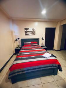 科罗尔Paradise Comfort的一间卧室配有一张红色和蓝色条纹的大床