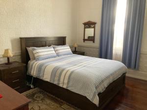 班伯里Rose Cottage的一间卧室配有带条纹棉被的床和窗户