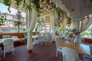 圣弗拉斯Mia Cassa的一间设有白色椅子和桌子的餐厅,种植了植物