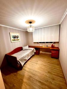 里贝拉ÁTICO RIBEIRA CENTRO的一间卧室配有一张床、一张桌子和一个吊灯。