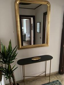 罗马Eur Centro lux apartment con camino的镜子和桌子,放在一个植物的房间