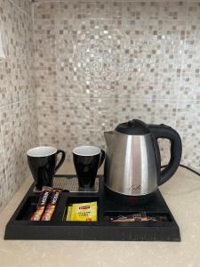海若克利欧La casa de campo的柜台托盘上的咖啡壶和两个杯子