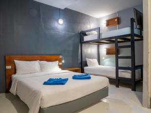 甲米镇Leisure Hostel的一间卧室配有两张床和一张双层床。