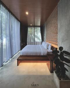 Ban Rang PlaSANTI beach retreat的一间卧室设有一张床和砖墙