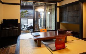 南阿苏村别邸苏庵传统日式旅馆的客厅配有木桌和电视。