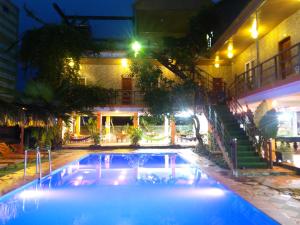 峰牙Phong Nha Dawn Home的一座建筑物中间的游泳池