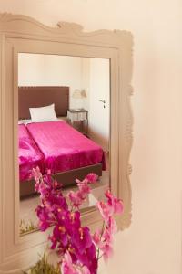 欧拉努波利斯Emmeleia Accommodation by Maria Riga的卧室配有粉红色的床和镜子