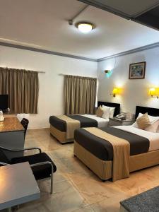 迪拜Grand Astoria Hotel的酒店客房设有两张床和一张桌子。