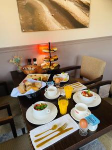 米德尔克尔克Villa La Dune - Ontbijt & parking inclusief的一张桌子,上面有早餐食品和饮料