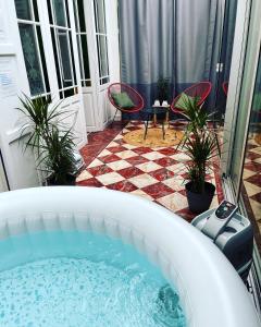 特鲁瓦Bed & Bulles-Jaccuzzi-Parking的庭院设有热水浴池、椅子和桌子