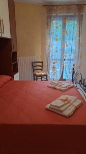 兰恰诺Casa Vacanze “ Fonte del Borgo”的一间卧室配有红色的床和2条毛巾