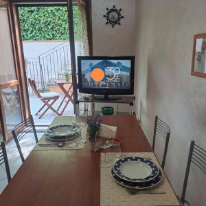 兰恰诺Casa Vacanze “ Fonte del Borgo”的餐桌、盘子和电视