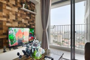 胡志明市Landmark View 2 bedrooms condo in T1 Masteri Thao Dien, Fully Furnished With Full Amenities的一间带电视和大窗户的客厅