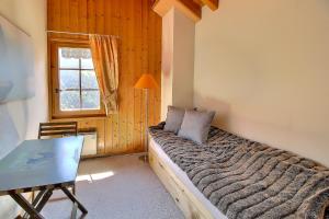尚佩里Triplex Overlooking The Village - Terrace & Bbq的一间卧室配有一张床、一张桌子和一个窗户。