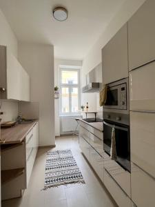 维也纳NEW Exclusive 100m2, Top location!的厨房配有白色橱柜和微波炉