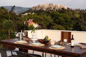 雅典Visum Acropol ,3BR - Private Terrace-Jacuzzi - Amazing View的一张木桌,上面有花瓶