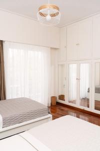 雅典Visum Acropol ,3BR - Private Terrace-Jacuzzi - Amazing View的一间白色卧室,配有两张床和吊灯