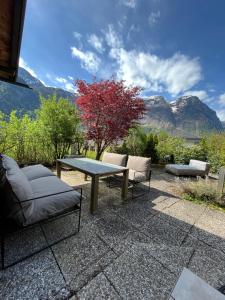 上特劳恩Chalet Obertraun的一个带桌子和两把椅子的庭院和山脉