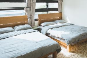 鴉埠客棧x南華大旅社的一间卧室设有两张床和窗户。