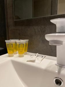 卡达克斯卡帕蒂姆卡达克斯酒店的浴室水槽上坐着三个黄色的杯子
