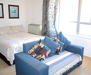 德班Unit 104 @Tenbury的一间卧室配有床、蓝椅和枕头