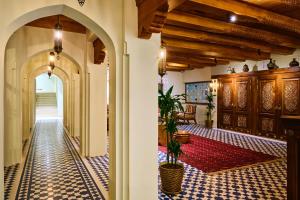 撒马尔罕Kosh Havuz boutique hotel的建筑中的拱门,铺着瓷砖地板