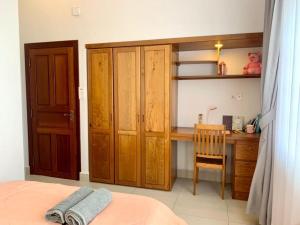 金边Ptas Tauch Residence的一间卧室配有书桌、一张床和一个木制橱柜
