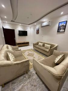 Abū Qa‘arAl Farhan Hotel & Suites Hafr Al Batin的带沙发和平面电视的客厅