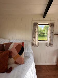 费克纳姆The Hideaway的一间卧室配有床和带窗帘的窗户