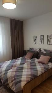 萨拉热窝Sarajevo New Apartments的一间卧室配有一张带铺着平底毯的床